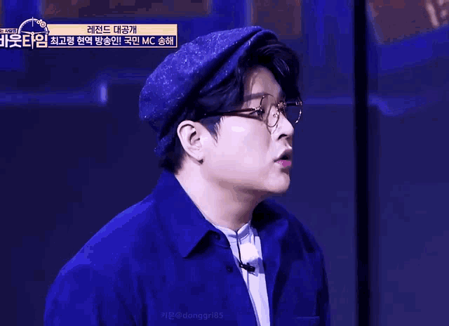 a man wearing glasses and a hat with a yellow sign that says donggr85