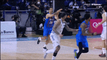 a basketball game is being played in front of a banco advertisement