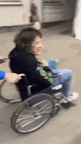 a person in a wheelchair is being pushed by another person .
