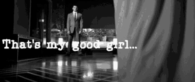a man in a suit and tie is standing in a room with the words that 's my good girl written on the floor