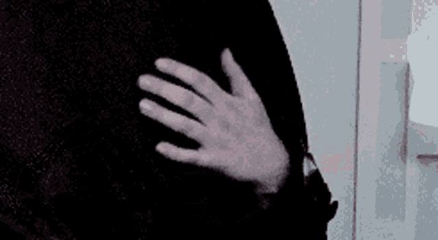 a close up of a person 's hand touching another person 's shoulder