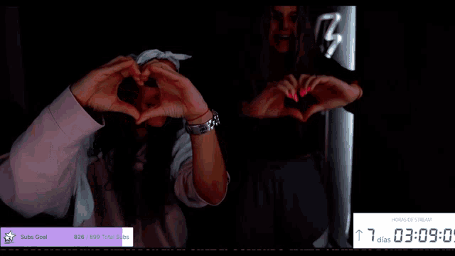 two women are making a heart shape with their hands in front of a screen that says suba goal
