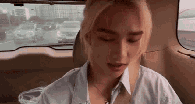a young man is sitting in the back seat of a car .