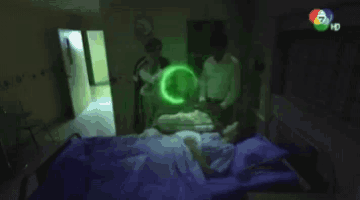 a person laying in a hospital bed with a green light coming out of their head