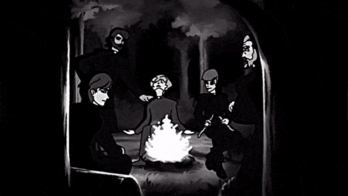 a group of people are sitting around a campfire
