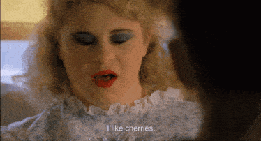 a woman with blue eyeshadow and red lipstick says i like cherries
