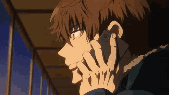 a man is talking on a cell phone while looking down