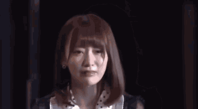 a woman with her eyes closed is making a funny face .
