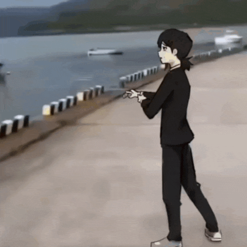 a man in a black suit is walking on a sidewalk near the water