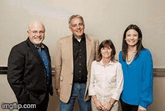 a group of people are standing next to each other and smiling for the camera .