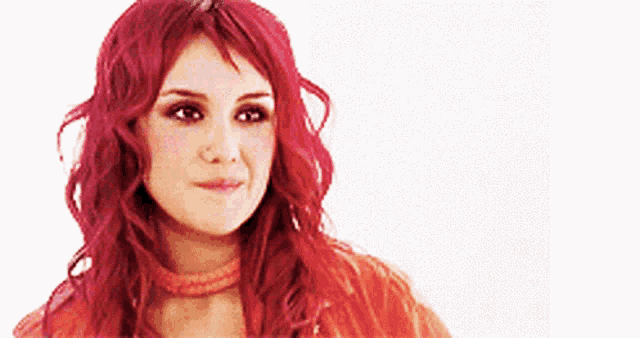 a woman with red hair is wearing an orange jacket and a choker .
