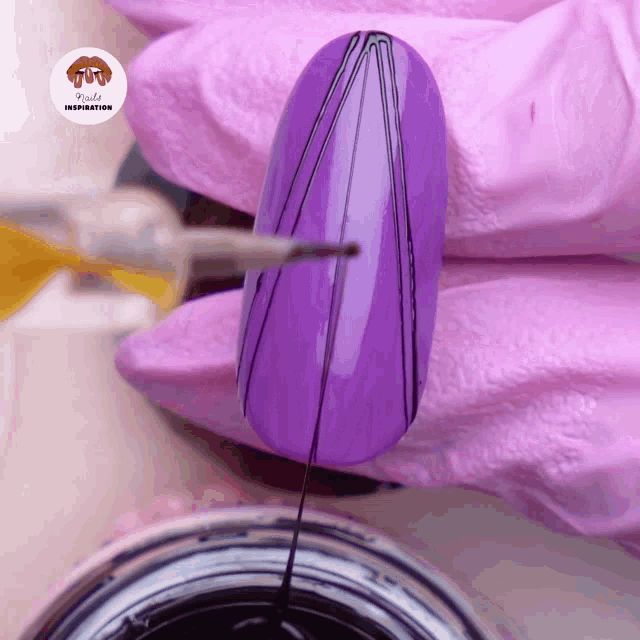 a purple nail is being painted with a brush and the words nails inspiration are visible