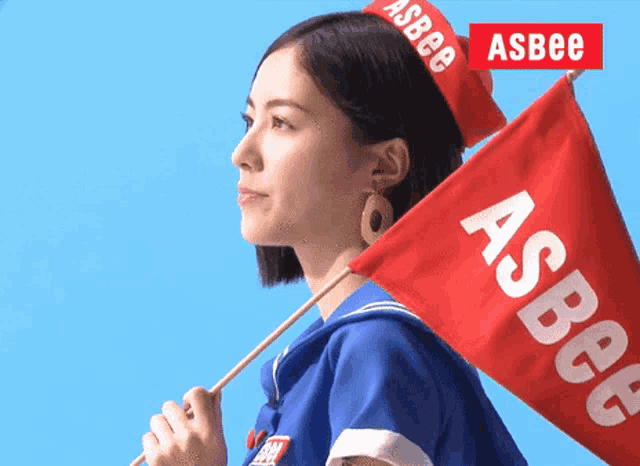 a woman holds a red flag that says asbee on it