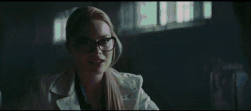a close up of a woman wearing glasses and a tie .