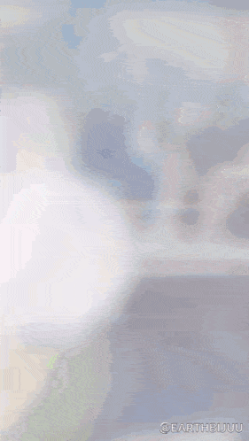 a blurred image of a person holding a cell phone with the words " earthbujuu " on the bottom