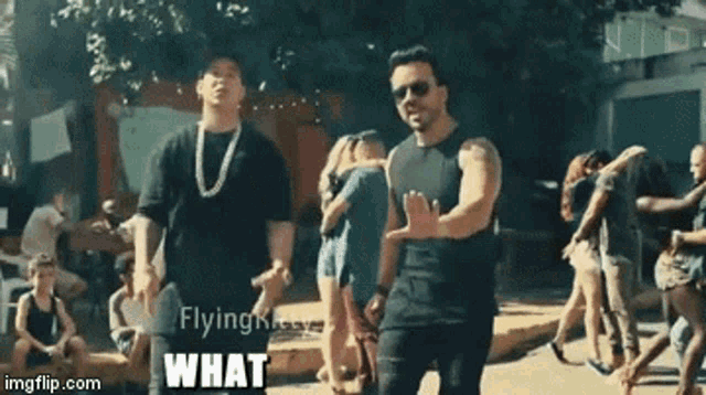 two men are dancing in front of a crowd and the words what are visible