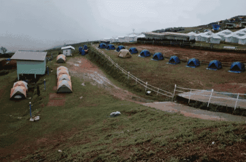 a row of tents are lined up on a hillside