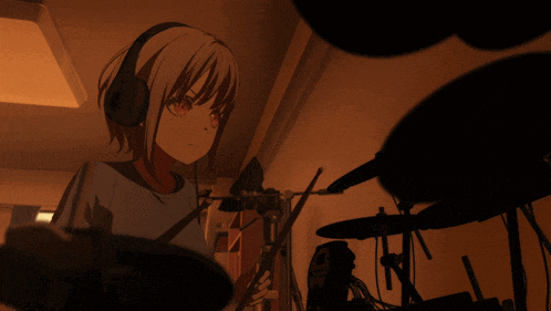 a girl wearing headphones playing a drum set