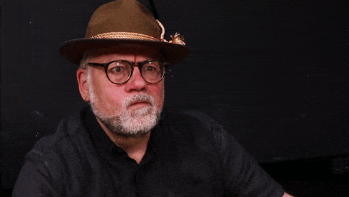 a man wearing a hat and glasses with the words ik zit er helemaal naast above him