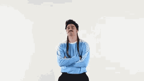 a man with a mustache and a mullet is giving the middle finger .