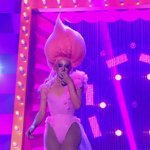 a drag queen wearing a pink bodysuit and a huge pink wig
