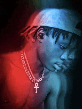 a shirtless man wearing a hat and a necklace with an ankh on it