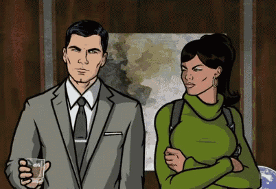 a man in a suit and tie is standing next to a woman in a green sweater .