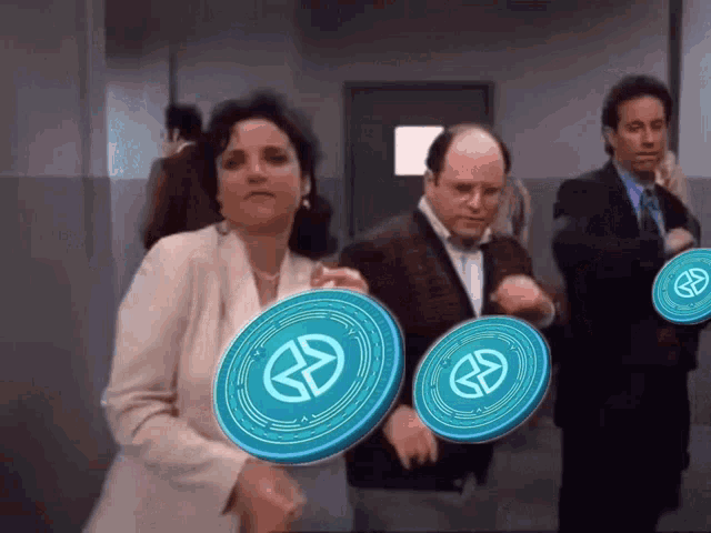 a man in a tuxedo and a woman in a white jacket are holding frisbees with the letter s on them
