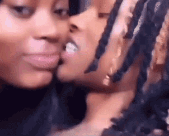 a couple of women kissing each other on the cheek .