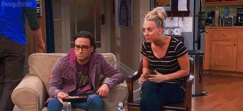 a man and a woman are sitting on a couch and a man is standing behind them