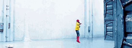 a person in a yellow jacket and red boots is jumping in the air in front of a wall that says dmg