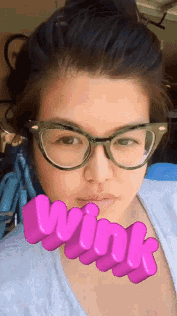 a woman wearing glasses has the word wink written in pink