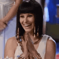 a woman is smiling and clapping her hands while wearing a costume .