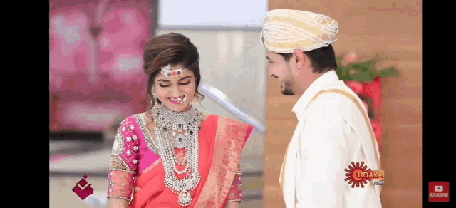 a bride and groom are standing next to each other and the bride is wearing a red dress