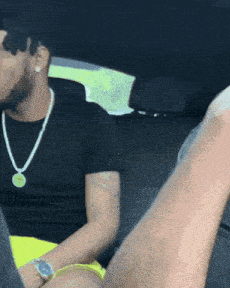 a man wearing sunglasses and a watch is sitting in the back seat of a vehicle
