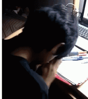 a man is sitting at a desk with a laptop and a clipboard