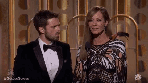 a man in a tuxedo is standing next to a woman in a dress .