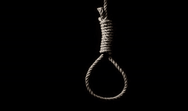 a hangman 's noose is hanging from a rope in the dark .