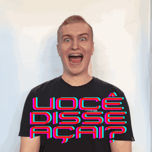 a man with braces on his teeth is wearing a shirt that says voce disse acai ?