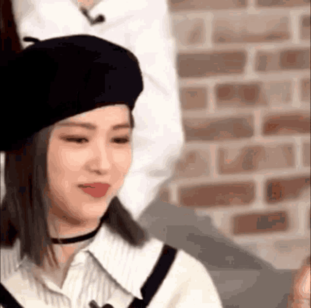 a close up of a woman wearing a black beret and a choker .