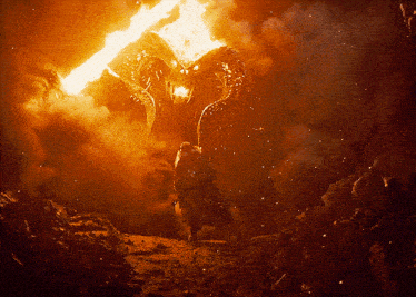 a man is standing in front of a monster with flames coming out of its head