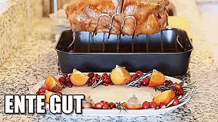 a roasted turkey is sitting on a rack above a plate of cranberries and oranges with the words ente gut below it