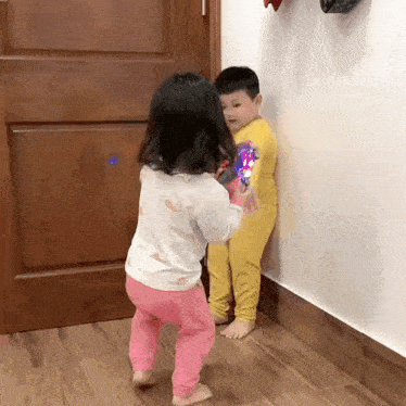 a boy and a girl are standing next to each other in a room .