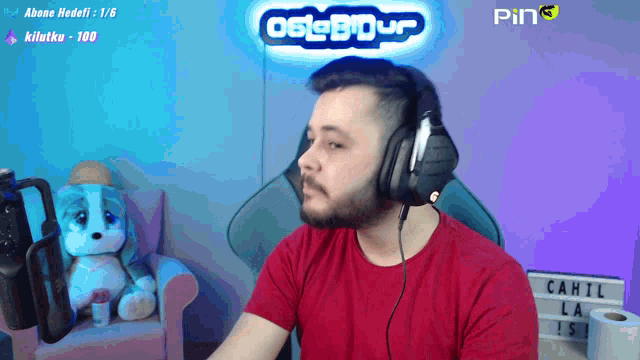 a man wearing headphones in front of a sign that says ping