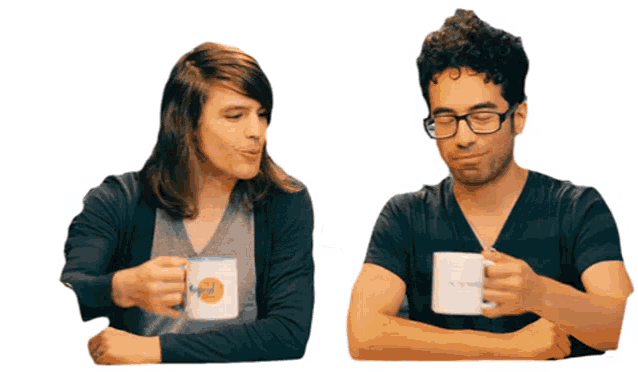 a man and a woman are sitting at a table drinking coffee and one of the cups has the word " nespresso " on it