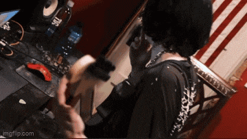 a person playing a guitar in front of a computer with a mouse and a bottle of water