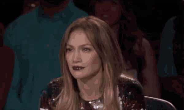 a woman in a sequined dress is sitting in a chair in a crowd .