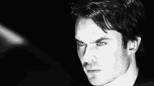 a black and white photo of a man with a beard and green eyes