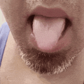 a close up of a man 's mouth with his tongue sticking out