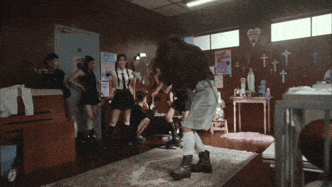 a group of girls are in a room with crosses on the walls